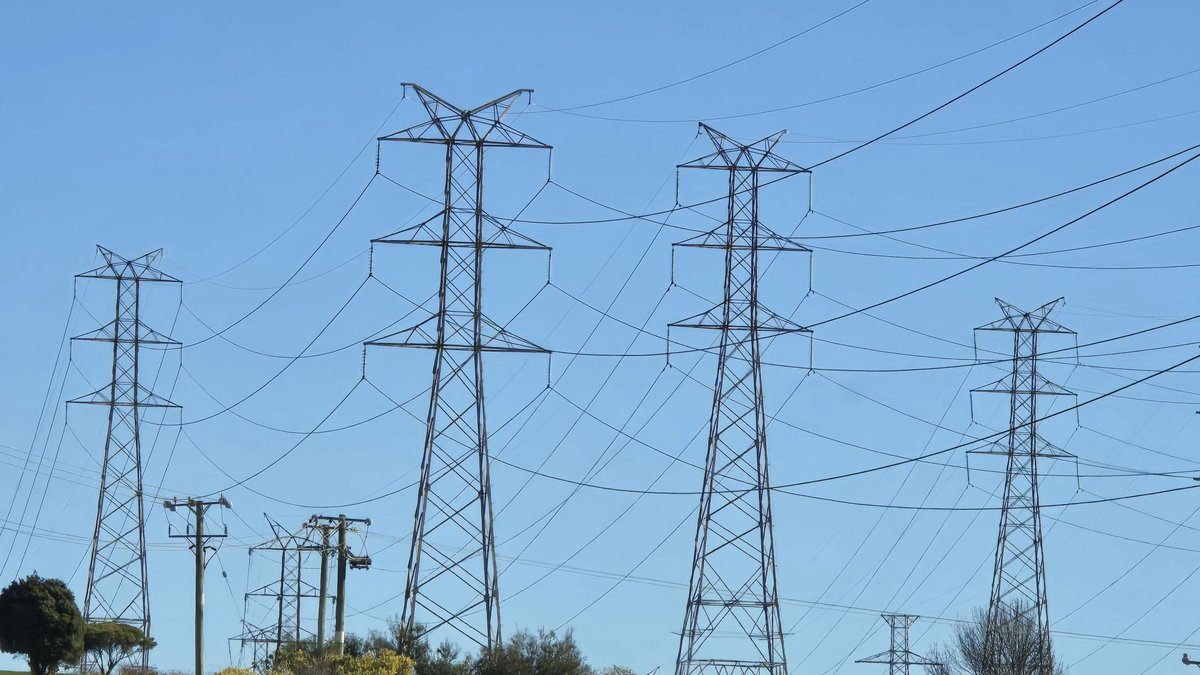 High-voltage transmission towers carrying power lines across open ground at Bell Bay in northern Tasmania.